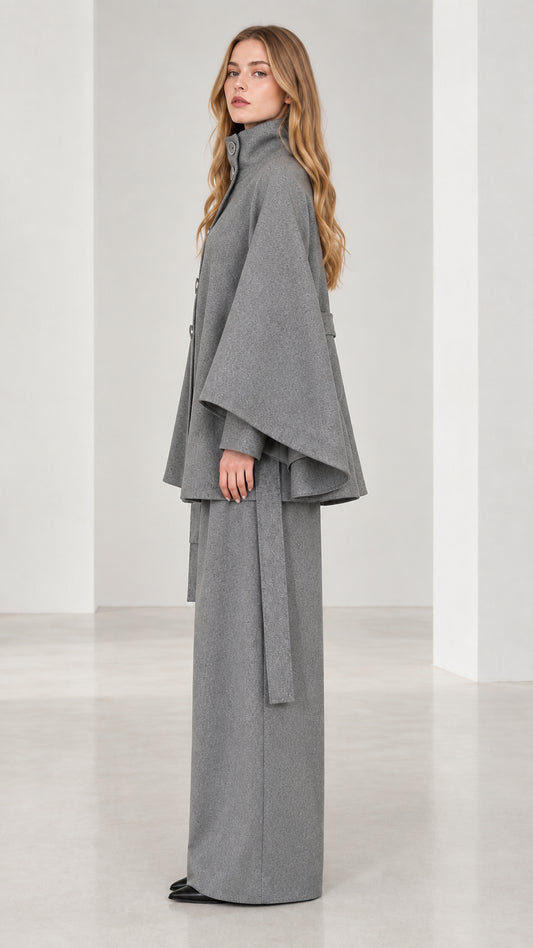 Side profile view of grey belted cape coat and flowy wide-leg trousers set