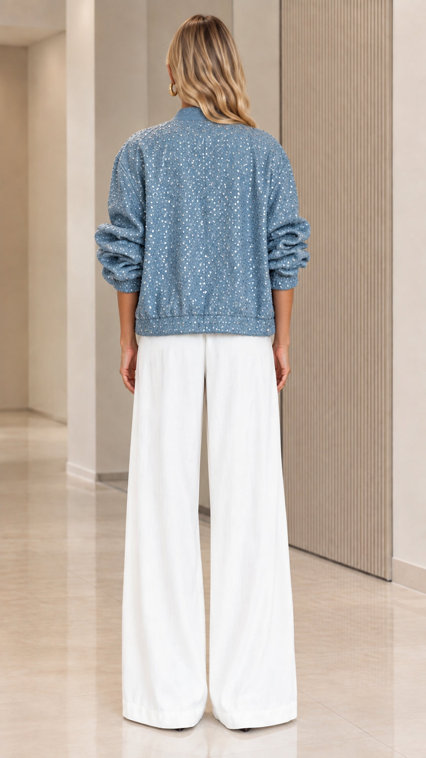Back view of dusty blue sequin bomber jacket showing relaxed fit and ribbed hem