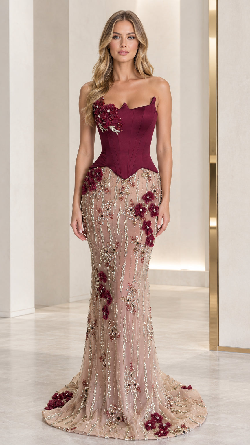 Front full-length view of model in burgundy strapless corset mermaid gown with floral embroidery