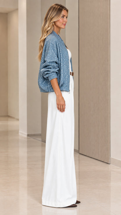 Side profile view of woman modeling dusty blue sparkly zip-up bomber jacket