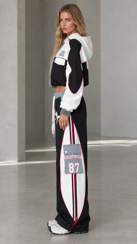 Side profile of model wearing black two-piece streetwear tracksuit set