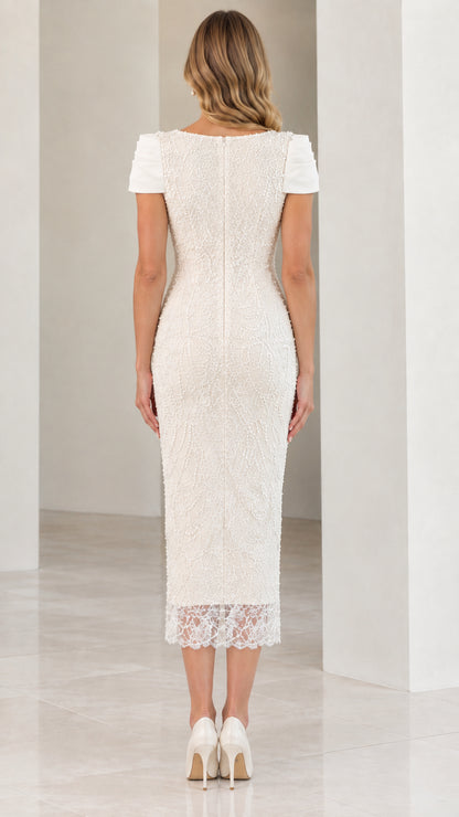 Back view of woman wearing Ivory beaded midi dress showing back zipper and walking slit
