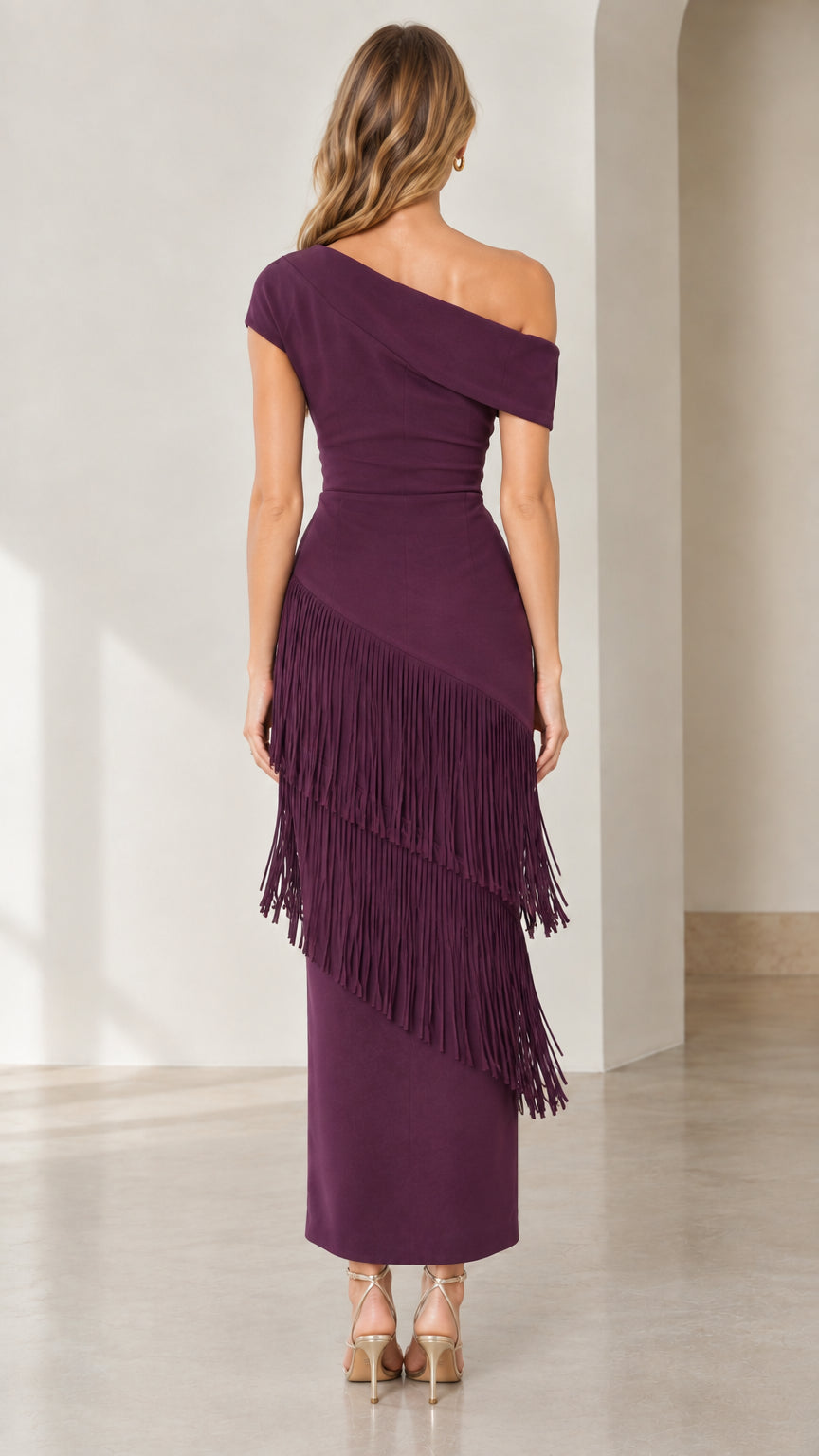 Back full-length view of woman wearing plum asymmetrical fringe cocktail dress