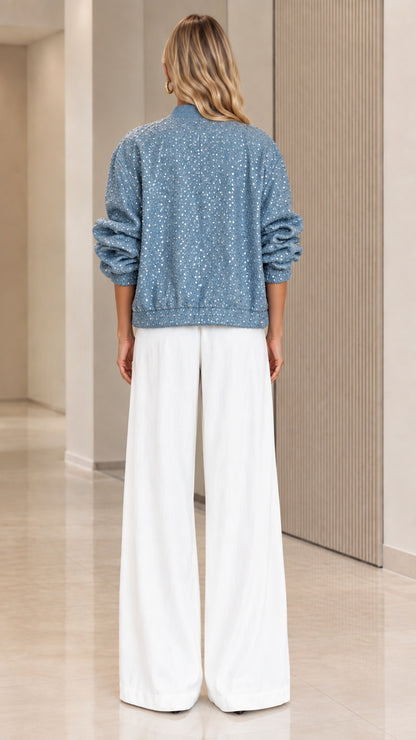 Back view of dusty blue sequin bomber jacket showing relaxed fit and ribbed hem