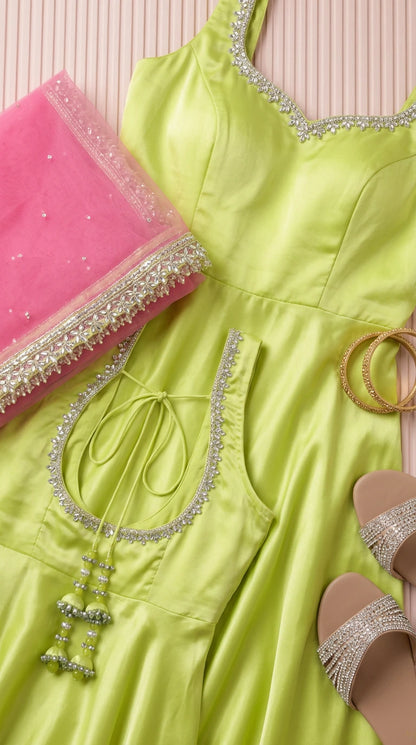 Flat lay close-up of lime green gown bodice detailing neckline embroidery and pink border dupatta