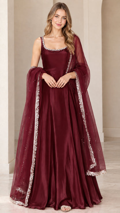 Front view of model wearing deep burgundy flared sleeveless evening gown with matching dupatta